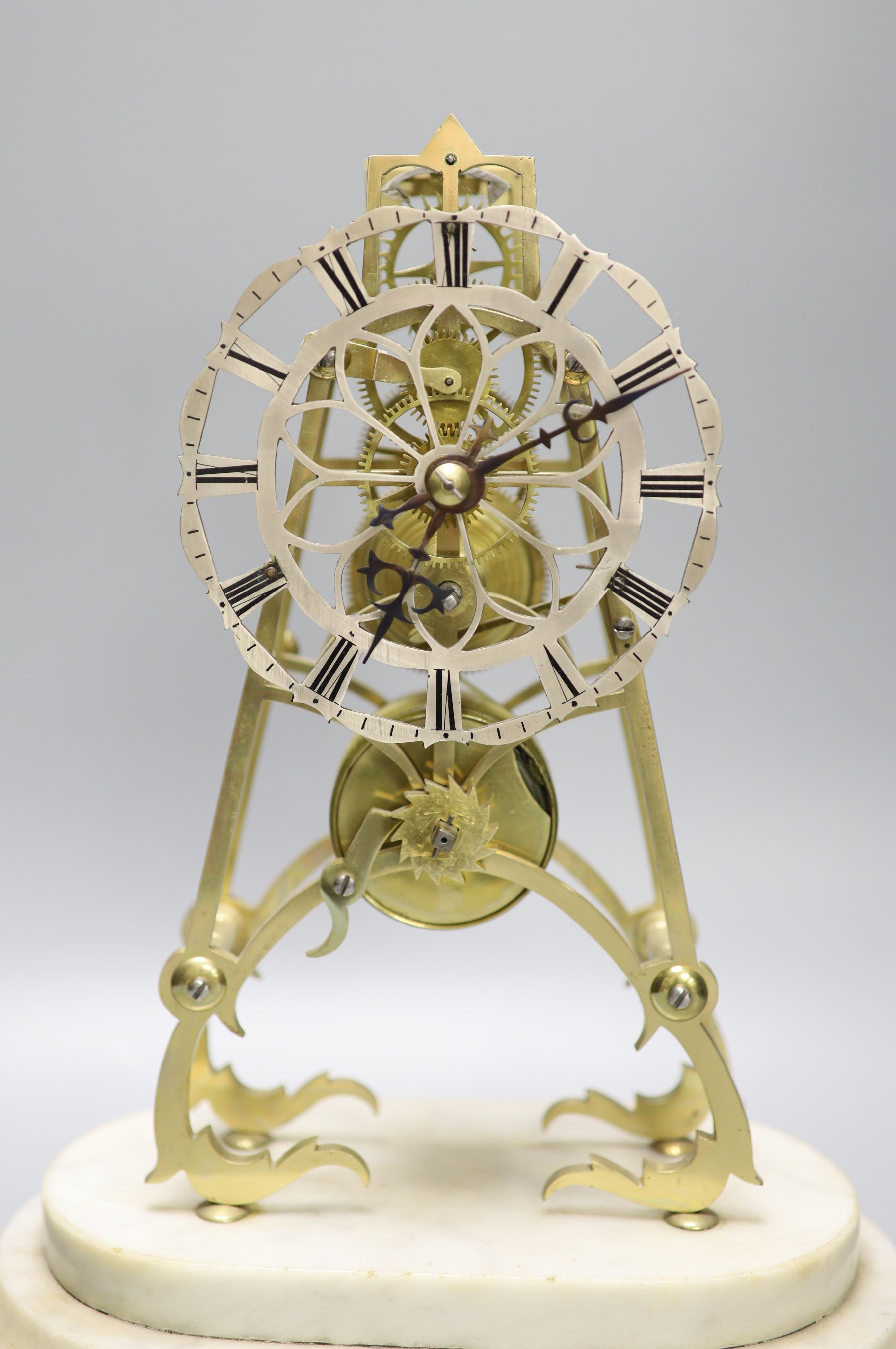 A 19th century brass skeleton clock on marble base. Associated glass dome, total height 44.5 cm